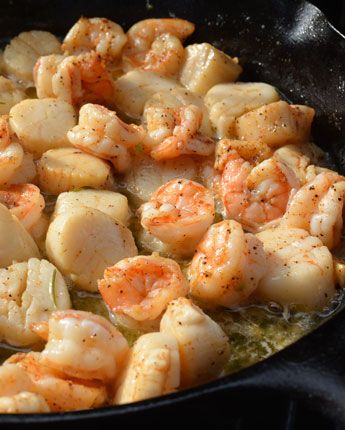 shrimp and scallops cooking in a skillet