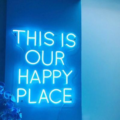 a neon sign that says this is our happy place