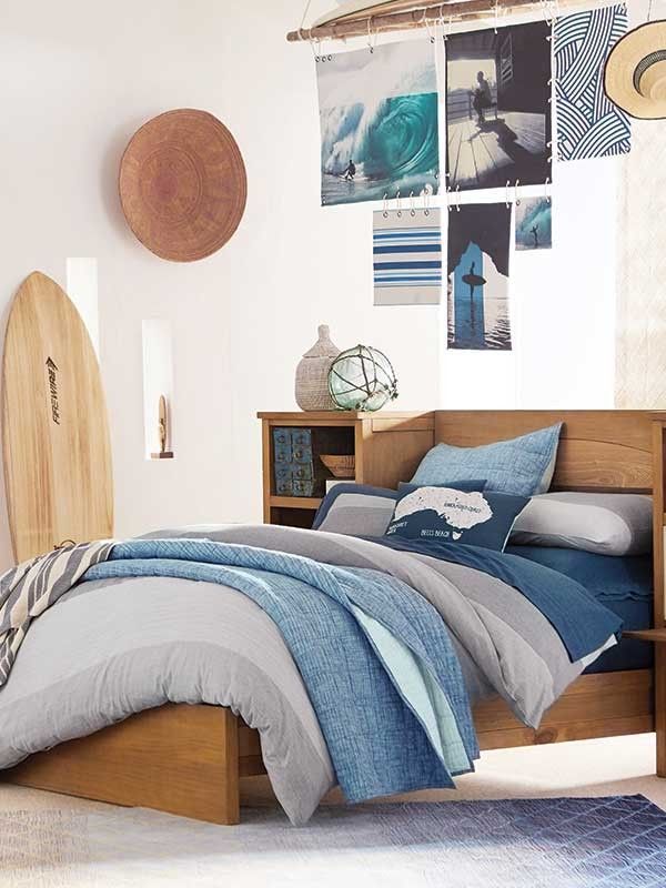 a bed room with a neatly made bed next to a book shelf and bookshelf