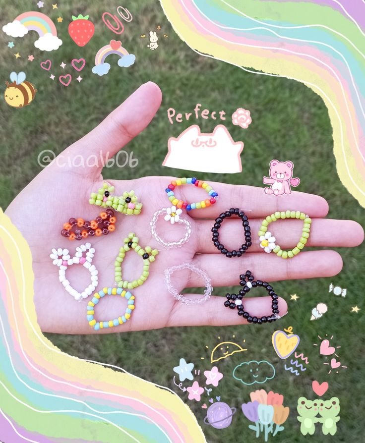 a person's hand with many different bracelets and rings on it in the grass