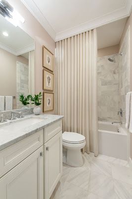 a bathroom with marble counter tops and white cabinets, along with a toilet and bathtub