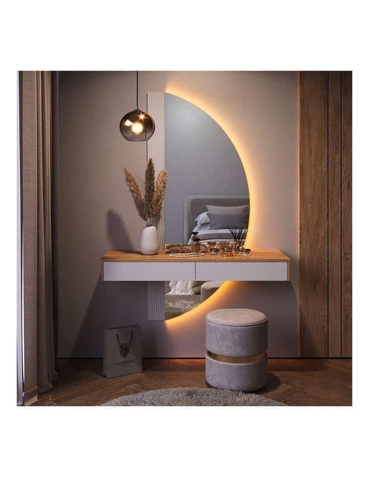 a mirror sitting on top of a white counter next to a stool and table with a plant