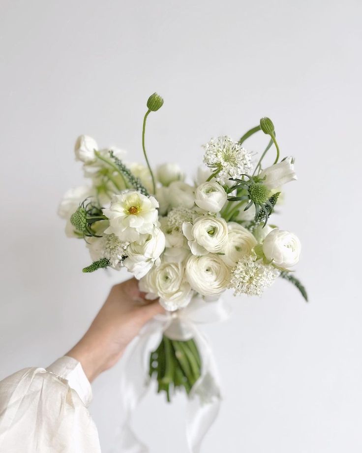 a person holding a bouquet of white flowers