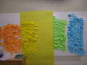 three bulletin boards covered in sticky notes on a whiteboard with the words wall of change written on them