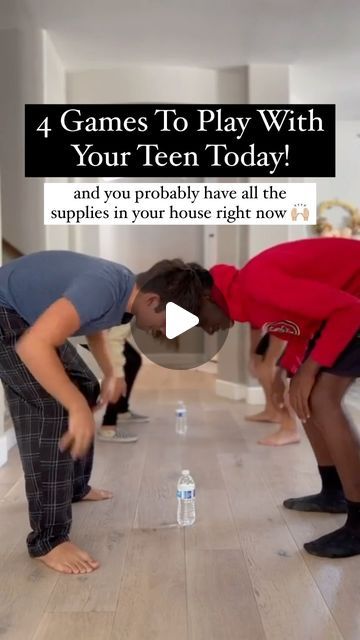 two boys are playing with water bottles on the floor