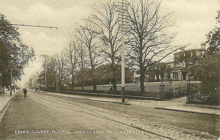 an old black and white photo of people walking down the street in front of houses