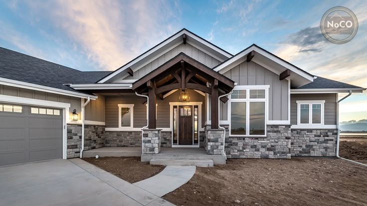 a house that is in the middle of a dirt lot with two garages on each side