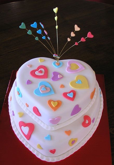 there is a heart shaped cake on the table with many hearts and sticks sticking out of it