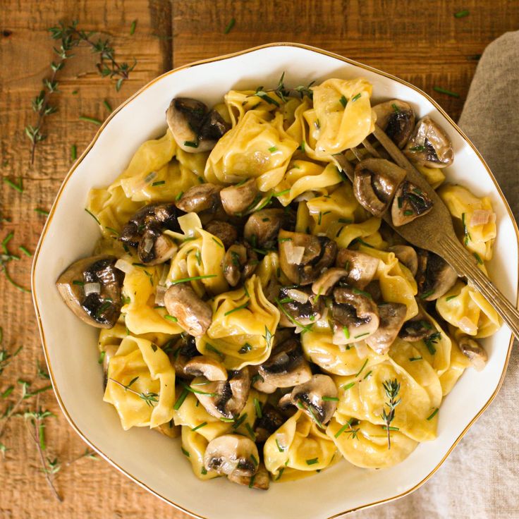 a white bowl filled with pasta and mushrooms