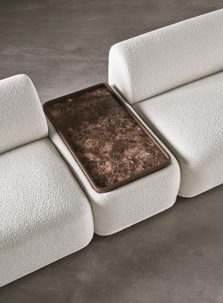 a close up of a white couch with a brown table in the middle of it