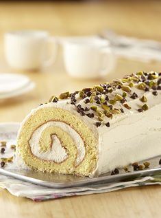 a cake roll is sitting on a plate with chocolate chips and sprinkles