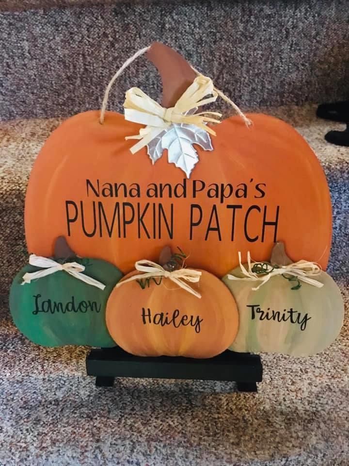 three pumpkins with names on them sitting in front of a carpeted stair case