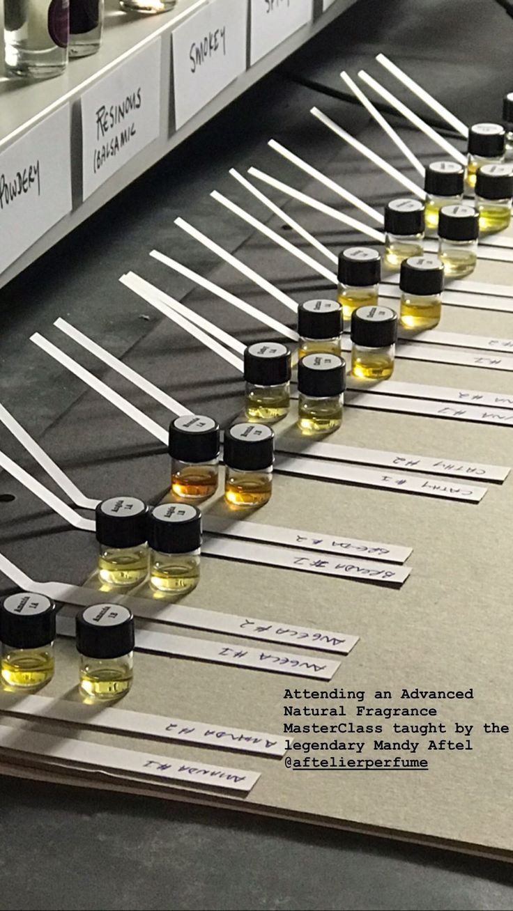 rows of bottles are lined up on a table in front of test tubes and labels