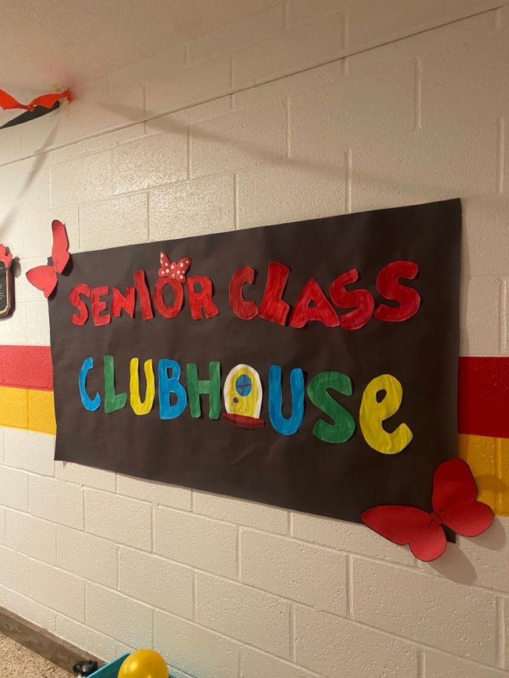 a sign that says senior class clubhouse hanging on the wall in a school hallway