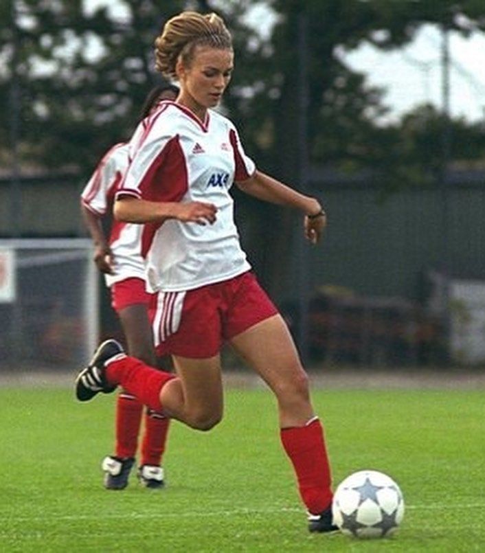 two girls are playing soccer on the field