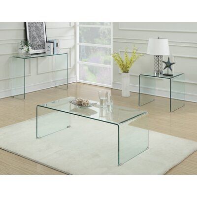 three glass tables sitting on top of a rug in front of a white wall and floor