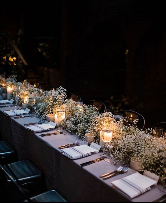 a long table is set up with candles and place settings for the guests to sit at