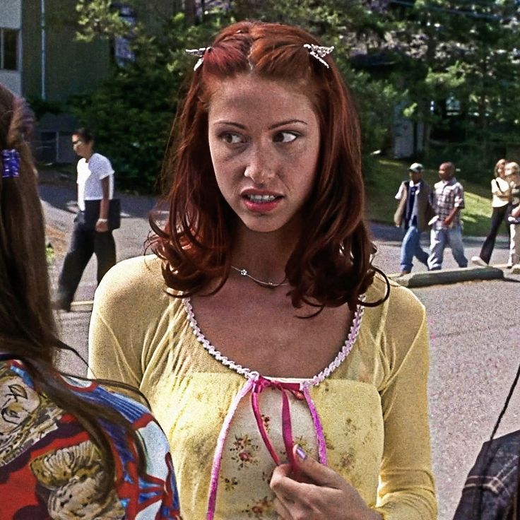 a woman with red hair wearing a yellow top