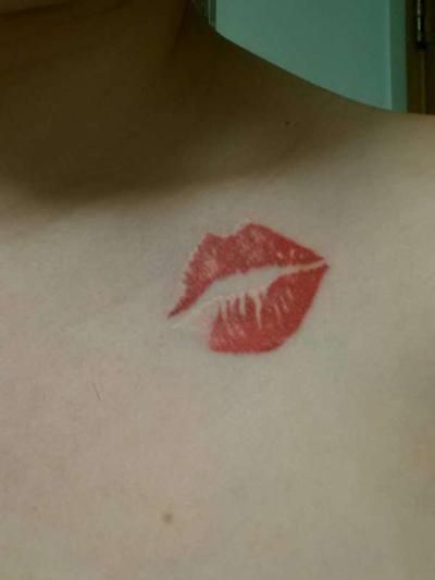 a woman's chest with red lipstick imprint on the top part of her chest