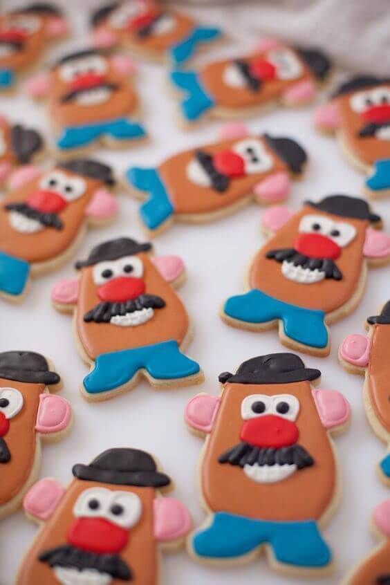 decorated cookies are arranged in the shape of cartoon characters on a white tablecloth with red, blue and black frosting