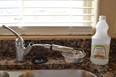 a kitchen sink with a faucet next to it and a bottle of cleaner