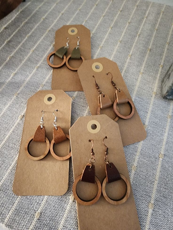 four pairs of wooden earrings sitting on top of a table