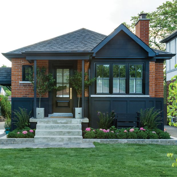 a house that is painted blue and has flowers in the front yard, along with steps leading up to it