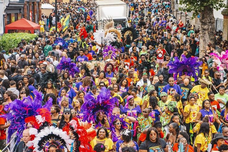 a large group of people are walking down the street in colorful outfits and headdress