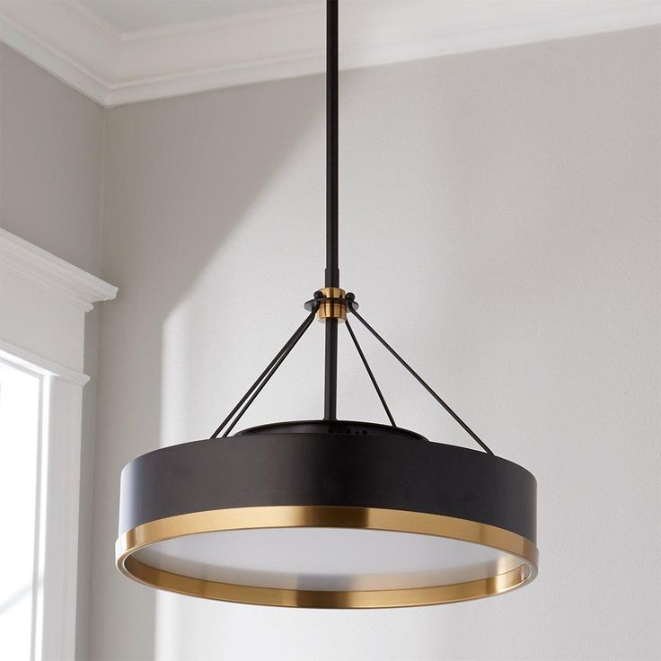 a black and gold chandelier hanging from a ceiling in a room with white walls