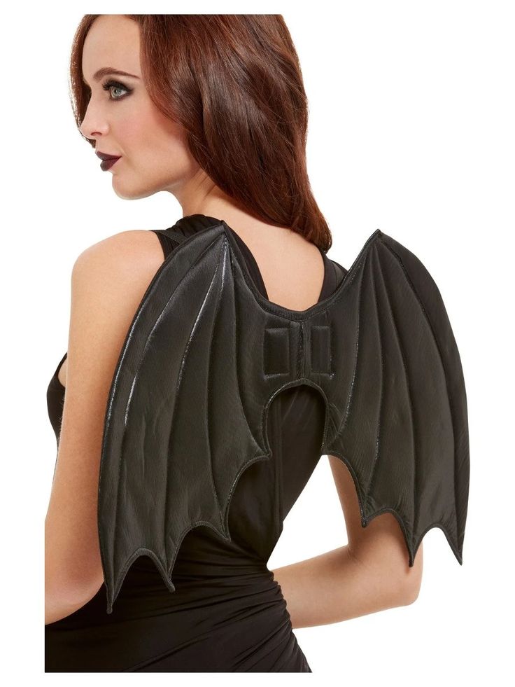 a woman in a black dress with a bat shaped back and wings on her shoulders