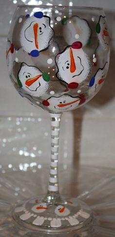 a wine glass with snowmen painted on it