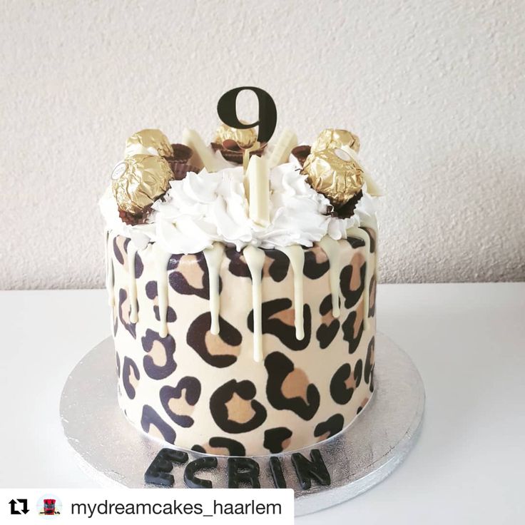 a leopard print cake with white frosting and gold decorations