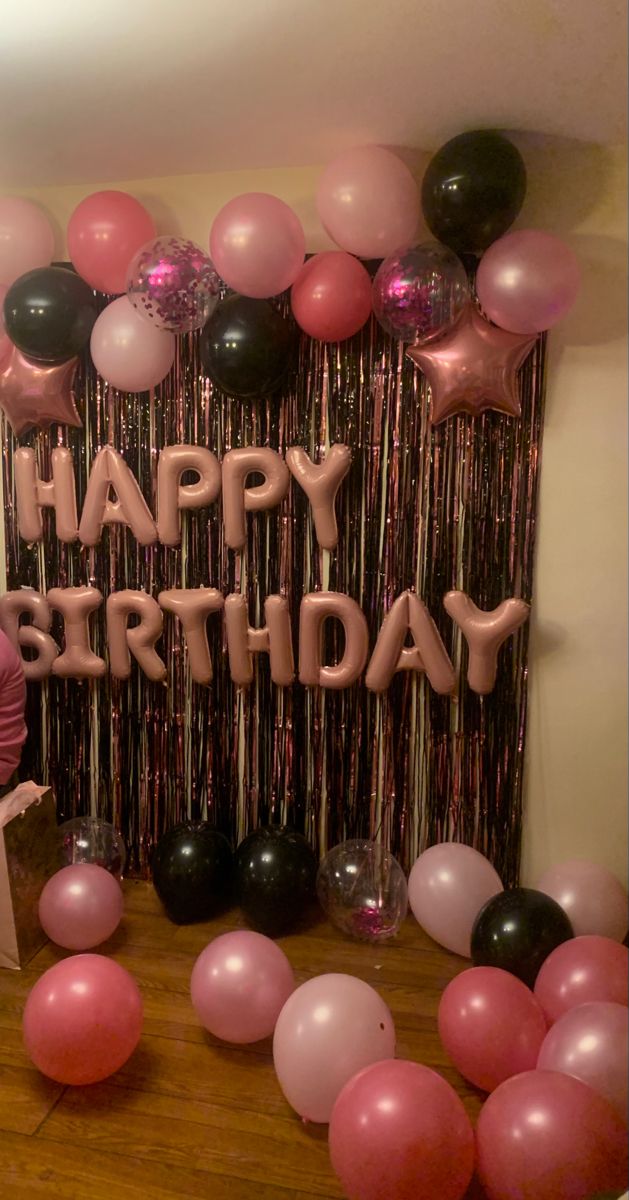 a birthday party with balloons and streamers on the wall in front of a happy birthday sign