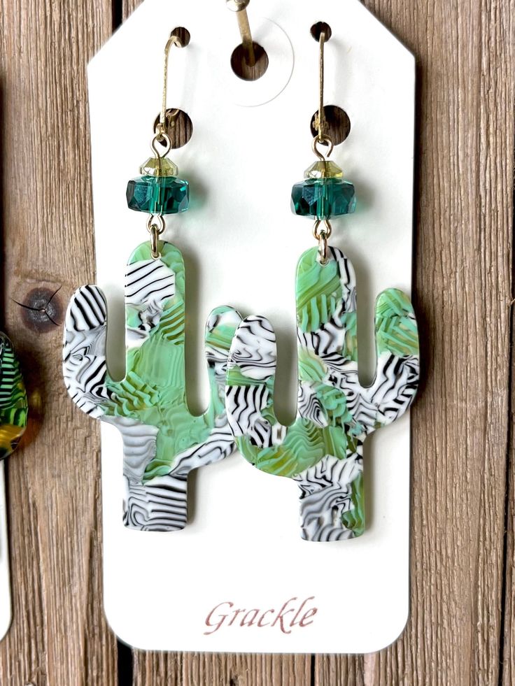 * Saguaro cactus charms made of lightweight cellulose acetate with iridescent green glass beads * Brass leverback earwires are lead and nickel safe  * Earrings hang approximately 3 inches  * Raw brass will tarnish naturally  * Patterns in acetate will vary * Handmade in Portland, OR Green Beaded Pierced Earrings, Whimsical Green Czech Glass Earrings, Trendy Green Beaded Dangle Earrings, Green Resin Earrings For Summer, Artsy Green Dangle Jewelry, Iridescent Green, Saguaro Cactus, Cellulose Acetate, Raw Brass