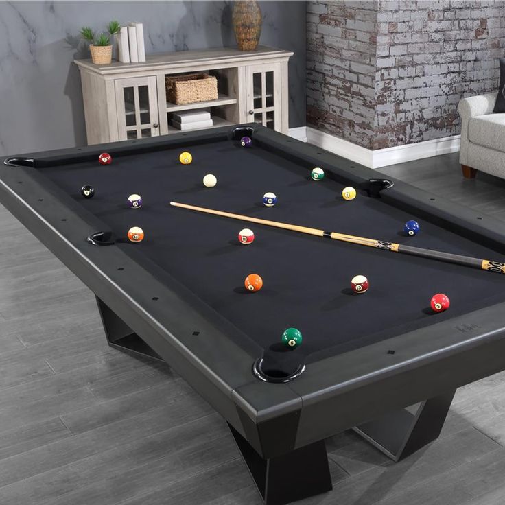 a black pool table with several balls on it