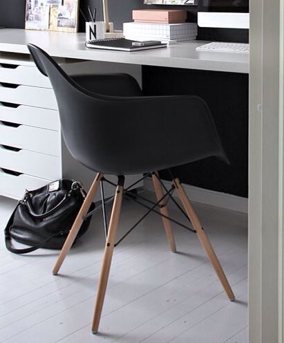 a black chair sitting in front of a white desk