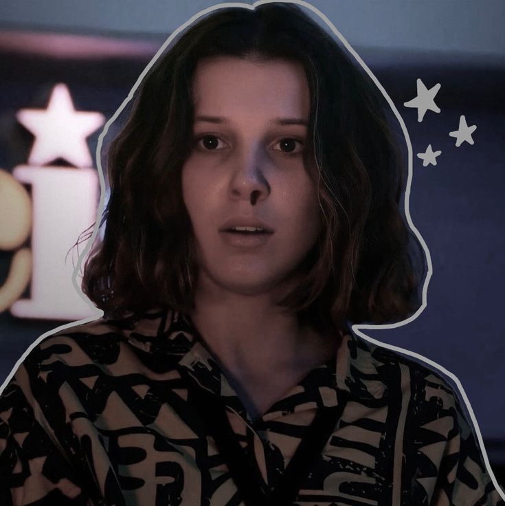 a woman in a black and white shirt looking at the camera with stars around her