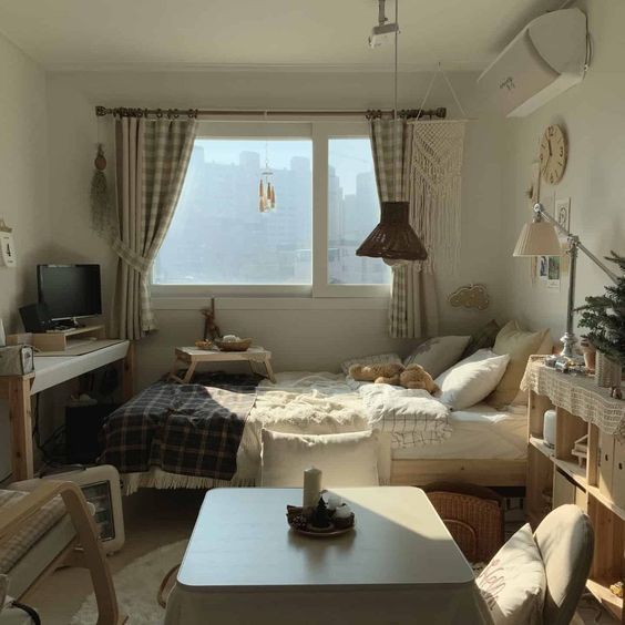 a bedroom with a bed, desk and television in it's corner area next to a window