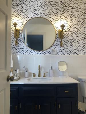 a white toilet sitting under a bathroom mirror next to a sink in a bath room