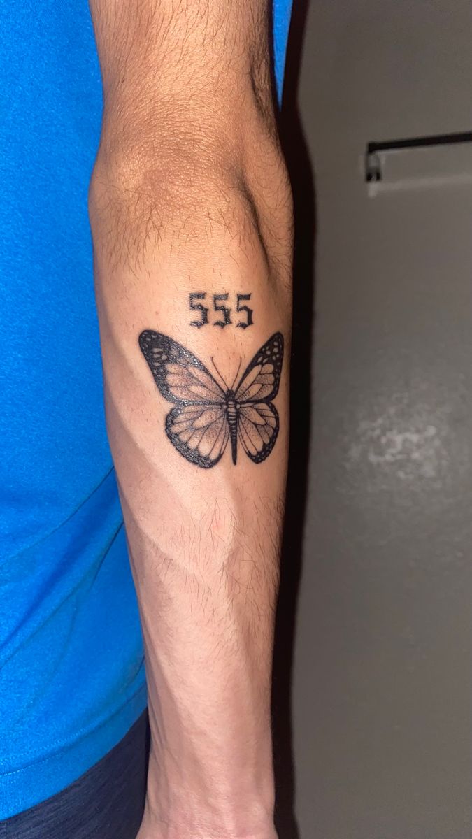 a man's arm with a butterfly tattoo on the left side of his arm