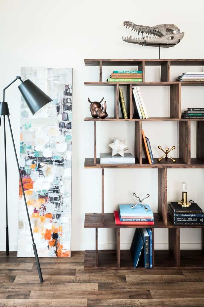 a bookshelf filled with lots of books next to a wall mounted animal head