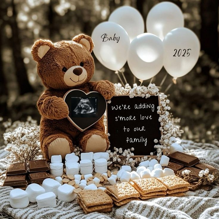 a teddy bear sitting on top of a blanket next to some cookies and marshmallows