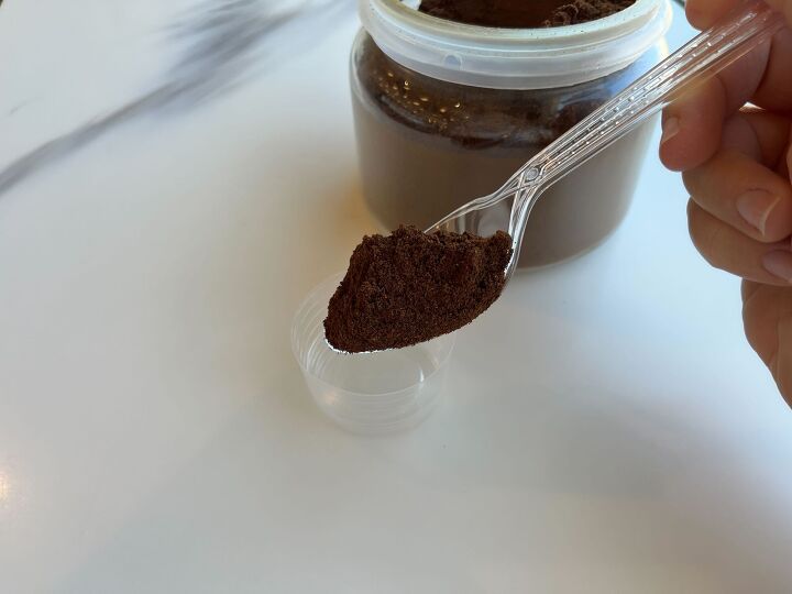 a person holding a spoon full of brown stuff