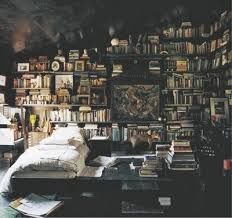 a bedroom with lots of books on the wall and a bed in front of it