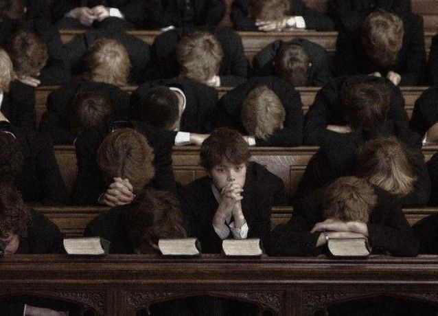 several people sitting in chairs with their backs to each other and one person covering his face