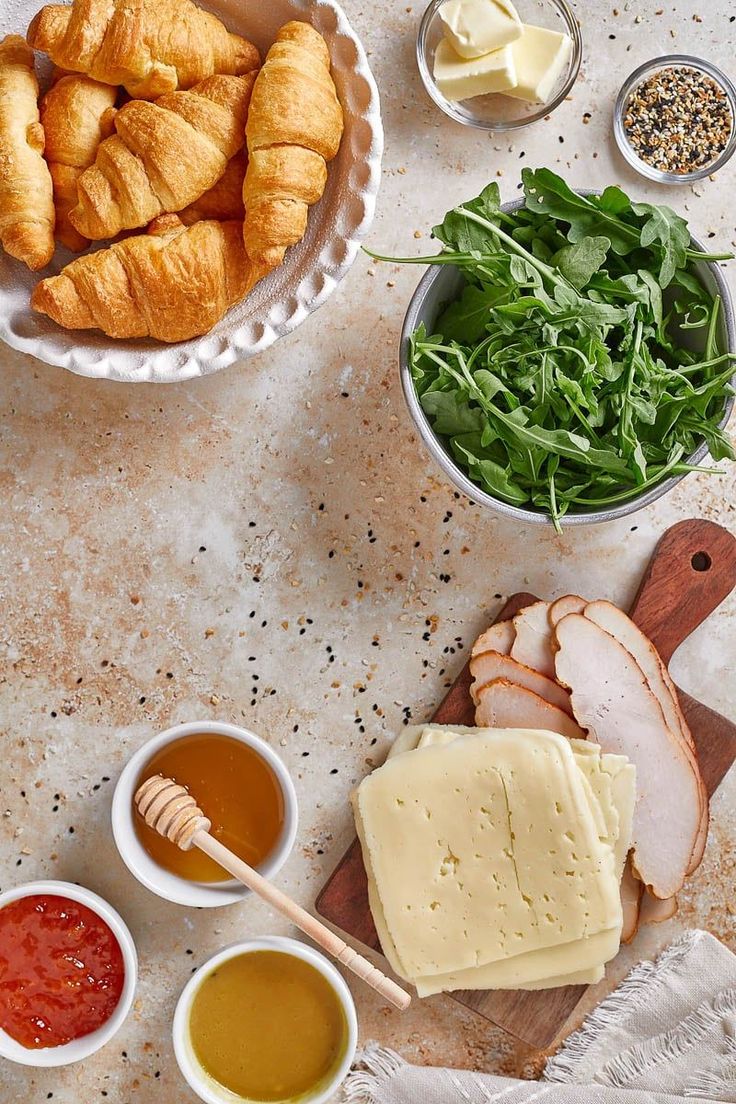 bread, cheese and other foods are arranged on a table