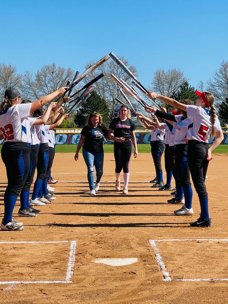 a group of young women standing on top of a baseball field