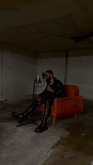 a man sitting on an orange chair with a microphone in his hand