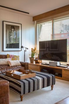 a living room filled with furniture and a flat screen tv on top of a wooden stand