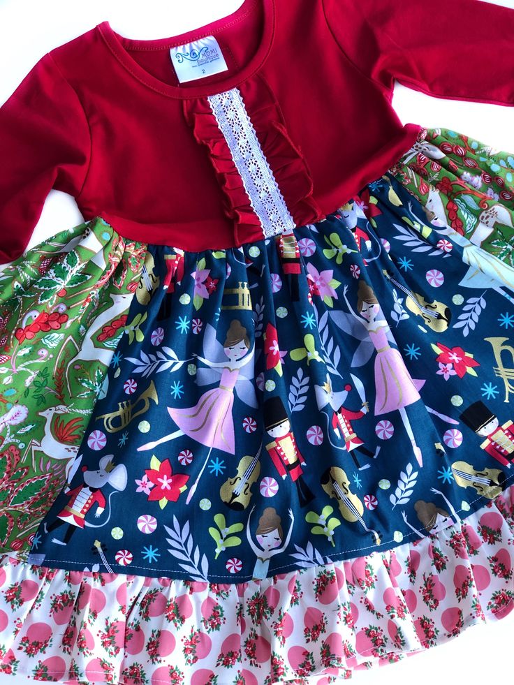 Set her apart from the rest! Our Enchanted Nutcracker dress is fashioned in our knit Buffalo plaid 2/3 style bodice & a cotton full ruffle skirting, perfect for wowing the crowd! Custom designed from a delightful mix of prints that please & soft colors that command compliments! Great for Christmas portraits, holiday parties, concerts, the Nutcracker ballet, & everyday wear!All designs are tagged in the even sizes. Dress: Size/length: 12mo: 17" 2: 21" 4: 24" 6: 26" 8: 28" 10: 31” 12: 33”Knit ches Fitted Red Dress With Gathered Skirt, Cute Cotton Tiered Dress, Cute Cotton Dress With Tiered Skirt, Fitted Cotton Dress With Ruffled Skirt, Cotton Ruffled Tiered Skirt Dress, Cotton Tiered Skirt Dress For Party, Cotton Tiered Skirt Party Dress, Playful Ruffled Dresses For Fall, Fitted Ruffle Holiday Dress For Dress-up